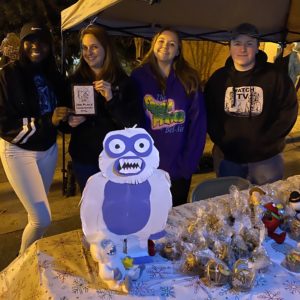 Alyssa Casey, FCS Teacher at CATA, poses with her students behind their table decorations. 